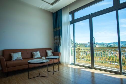 a living room with a couch and a large window at Win Villa Coffee in Da Lat