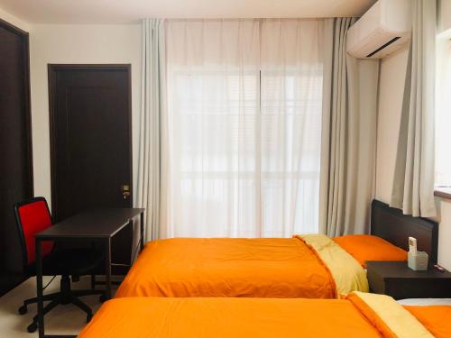 a bedroom with two beds and a desk and a window at K House in Tokyo