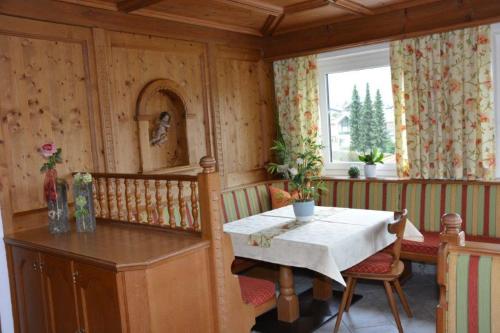 una sala da pranzo con tavolo, sedie e finestra di Haus Panorama a Reith im Alpbachtal