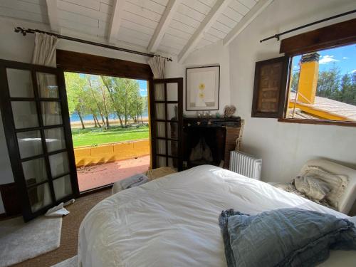 a bedroom with a bed and a large window at Casa Rural en el Pantano de Bolarque primera linea del lago in Auñón