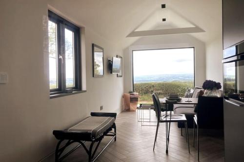 a kitchen and dining room with a table and chairs at The Cabin at Barnstormers, luxury woodland setting in Marldon