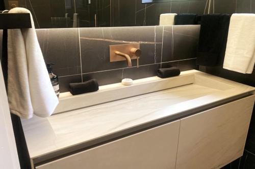 a bathroom with a white counter with a sink at The Cabin at Barnstormers, luxury woodland setting in Marldon