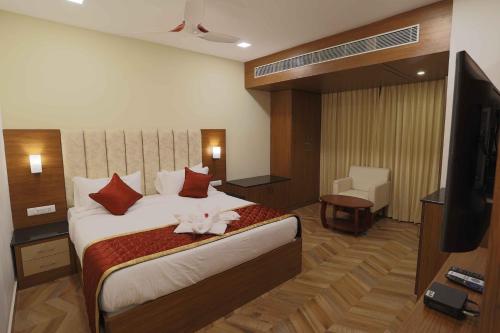 a hotel room with a large bed with a television at HOTEL BLUEMOON in Tirunelveli