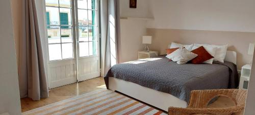 a bedroom with a bed and a large window at Vivenda Faria in Vila Nova de Milfontes