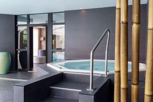 a bathroom with a jacuzzi tub in a house at Best Western Plus Le Roi Arthur Hôtel & Spa in Ploërmel