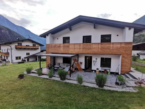 a white house with a patio in a yard at Das K - dei "Hoamatl" im Ötztal in Oetz
