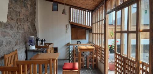 a kitchen with wooden tables and chairs and windows at Maison Fortaleza in Cusco