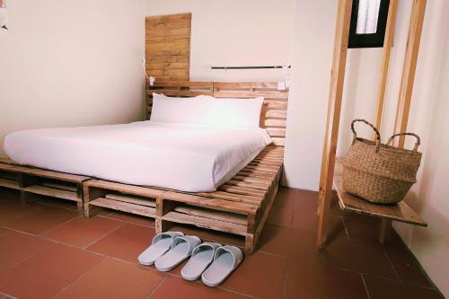 um quarto com uma cama e 2 pares de chinelos em 斜坡客棧 KIVALA Hostel em Jincheng