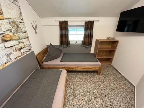 ヴァルトキルヒェンにあるFerienwohnung Roslのベッド2台とテレビが備わる小さな客室です。