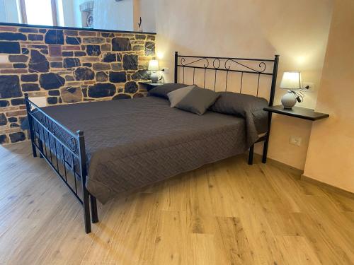 un grande letto in una stanza con un muro di pietra di LA DIMORA DEL BORGO a Levanto
