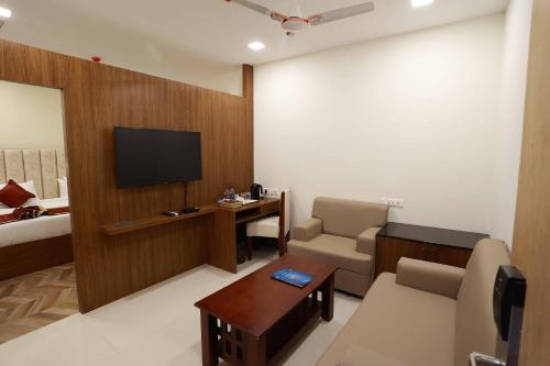 a hotel room with a television and a room with a bed at HOTEL BLUEMOON in Tirunelveli