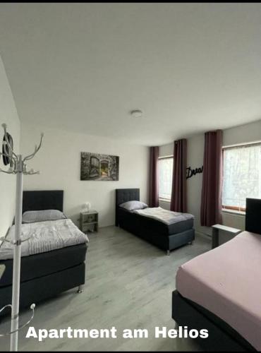 a hotel room with two beds and two windows at Central Apartment Krefeld in Krefeld