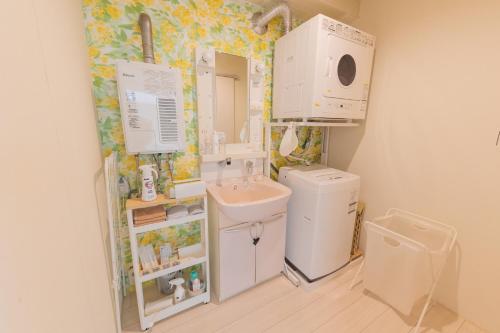 a small bathroom with a sink and a washing machine at million pointz in Amami