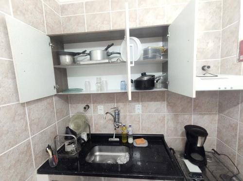 a kitchen with white cabinets and a sink at Apartamento vista pro Mar in Praia Grande