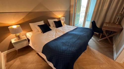 1 dormitorio con 1 cama grande con manta azul en Apartament Powiśle Deluxe, en Varsovia