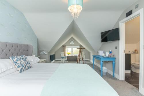 sypialnia z dużym białym łóżkiem i niebieskim stołem w obiekcie Seaview B&B w mieście Harwich