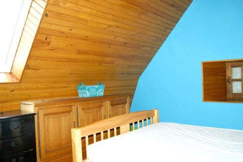 a bedroom with a bed and a wooden wall at Maison de 5 chambres avec vue sur le lac jardin clos et wifi a Menet in Menet