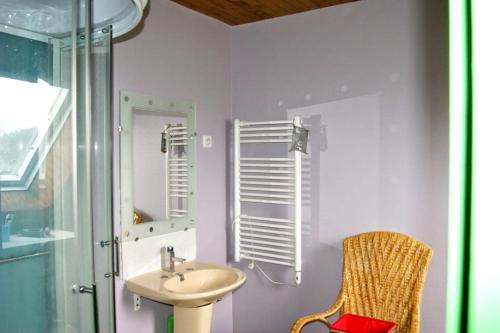 a bathroom with a sink and a mirror and a chair at Maison de 5 chambres avec vue sur le lac jardin clos et wifi a Menet in Menet