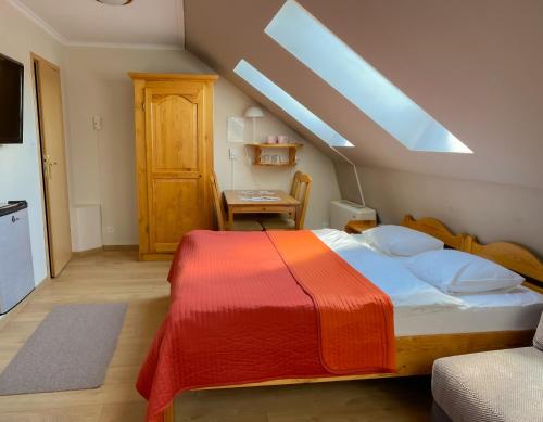 a bedroom with a bed with a red blanket on it at Aparthotel Mikołajki in Mikołajki