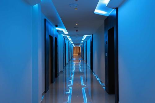 a corridor with blue lights in a building at HOTEL BLUEMOON in Tirunelveli