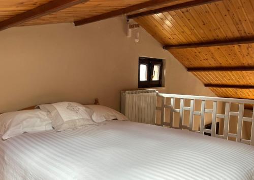 a bedroom with a white bed with a wooden ceiling at Ai house boutique in Castel di Sangro