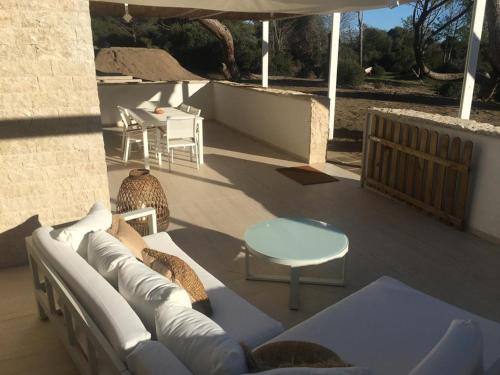 a patio with a couch and a table and an umbrella at Tenuta le marze in Castiglione della Pescaia