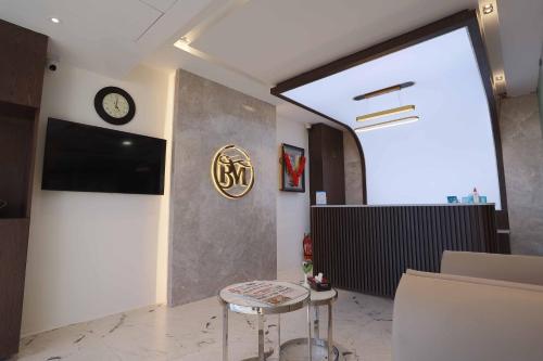 a room with a clock on the wall and a stool at HOTEL BLUEMOON in Tirunelveli
