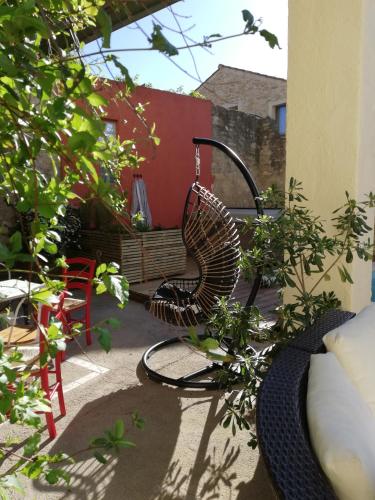 a rattan chair sitting on a patio with plants at Le Clos'art in Vinassan