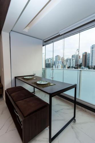 a dining room with a table and a large window at 360 Perdizes in Sao Paulo