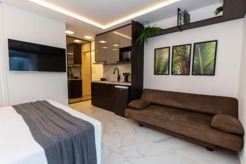 a bedroom with a couch and a kitchen at 360 Perdizes in Sao Paulo