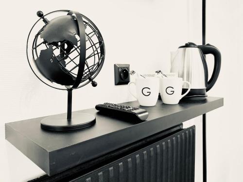 a black desk with a fan and cups and a coffee maker at Hôtel Gaspard in Le Touquet-Paris-Plage