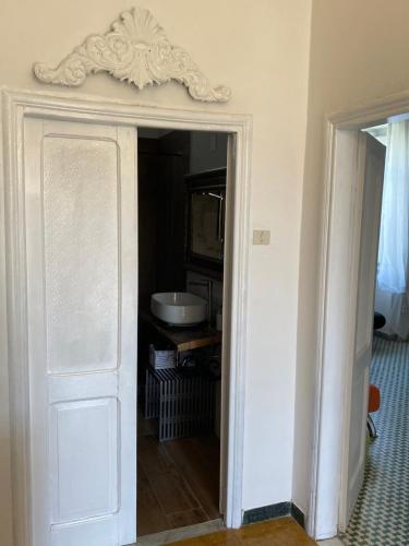 a white door in a room with a sink at alloggio turistico La Stalla in Tuscania