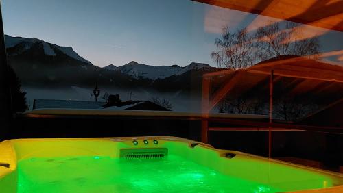 a hot tub in a room with a view of the mountains at Kranzmuehle - Ankommen am Achensee in Achenkirch