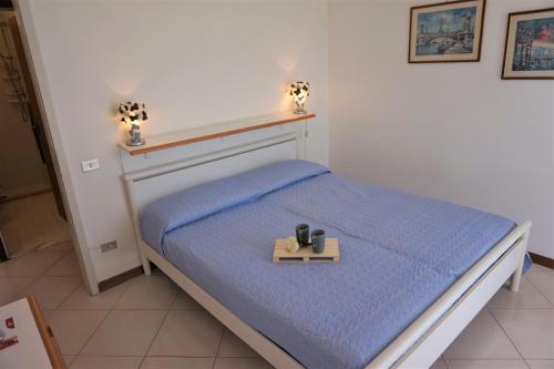 - une petite chambre avec un lit et un plateau dans l'établissement Residence Cristallo, à Lignano Sabbiadoro