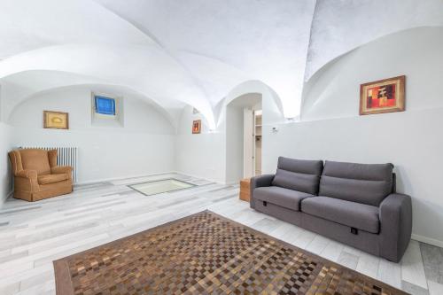 uma sala de estar com um sofá e uma cadeira em Il Golfo Apartments Duplex em Toscolano Maderno