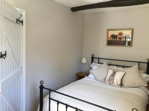 a bedroom with a bed with white sheets and pillows at Meal House in Narborough