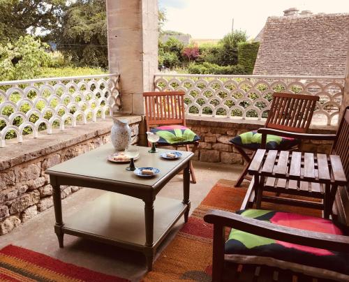 un patio con 2 sillas y una mesa en un porche en Abbot's Wing en Stroud
