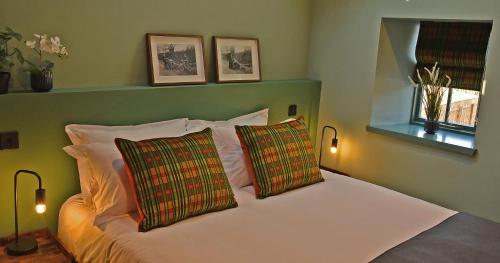 a bedroom with a white bed with two pillows at Masonic Arms Gatehouse in Gatehouse of Fleet