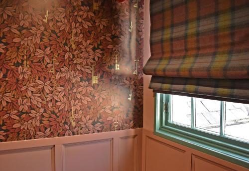 a room with a curtain and a window at Masonic Arms Gatehouse in Gatehouse of Fleet