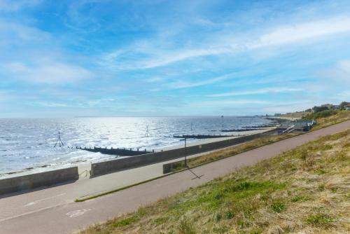 a road next to the ocean with a train on it at Seaview B&B in Harwich