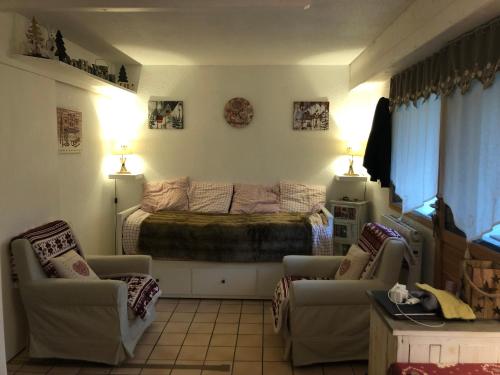 a living room with a bed and two chairs at Studio 4 personnes in Samoëns