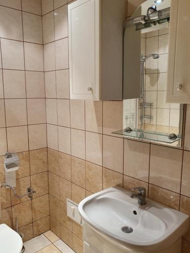 a bathroom with a sink and a mirror at Apartament 7 Bystrzycka - Bliżej Zdroju in Polanica-Zdrój