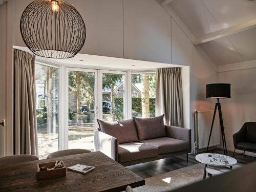 a living room with a couch and a table at Vakantiepark de Bosrand in Vaassen