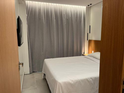 ein Schlafzimmer mit einem weißen Bett und einem Fenster in der Unterkunft Smart Salinas Premium Resort in Salinópolis