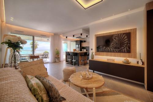 un salon avec un canapé et une table dans l'établissement Cannes Luxury Rental - Stunning sea front apartment, à Villeneuve-Loubet