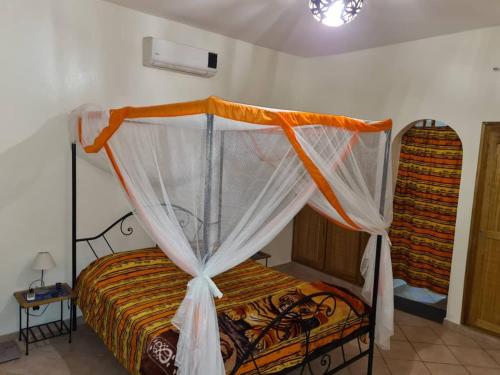 a bedroom with a bed with a canopy at keur GAANSOTI in Somone