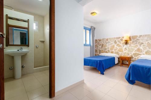 Pokój hotelowy z 2 łóżkami i umywalką w obiekcie Hostal Marina w Cala Ratjada