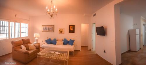 a living room with a couch and blue pillows at 2 bedrooms appartement with wifi at Penaflor in Peñaflor