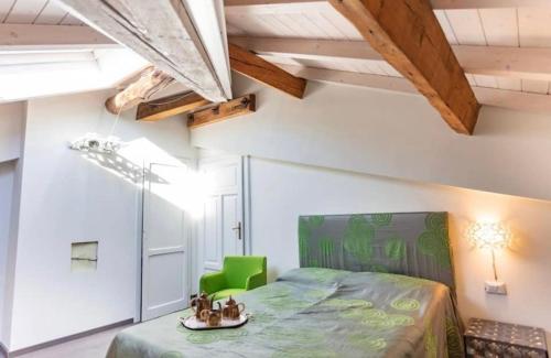 ein Schlafzimmer mit einem grünen Bett und einem grünen Stuhl in der Unterkunft Appartamento lusso con piscina tra Milano e Como in Costa Masnaga