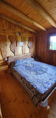 a bedroom with a bed in a log cabin at Cabañas La Escondida Casa De campo in San Antonio de Arredondo